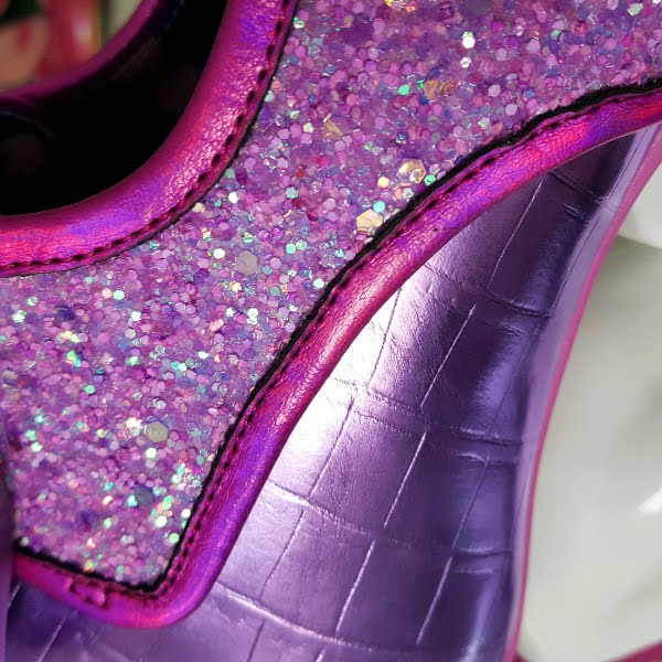 close up of purple glitter and metallic croc uppers on shoe