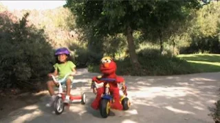 Elmo is riding his tricycle through the park. Elmo sings Elmo's Riding. Sesame Street The Best of Elmo 2