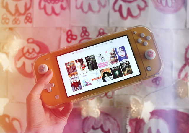A yellow Nintendo Switch Lite shows the Inkypen "my comics" page, showing the covers of 12 different comics.