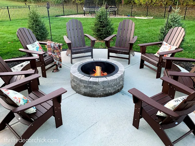 round fire pit with Adirondack chairs