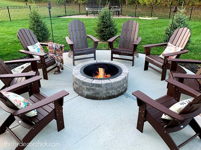 round fire pit with Adirondack chairs