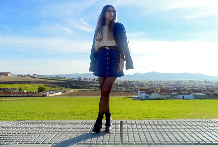 Falda denim acamapanda, jersey de punto rasgado, cazadora biker negra y botines de tacón con hebillas