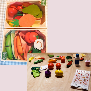 Verdure e frutta giocattolo in legno da tagliare e in feltro. In una foto sono sparpagliate sul tavolo insieme a degli adesivi, nell'altra sono in piccole cassette di legno, nella confezione originale.