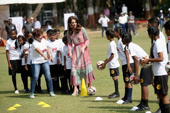 Catherine, Duchess of Cambridge joins in with ball games during a visit to meet children from Magic Bus