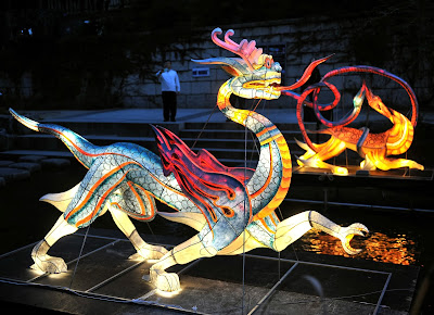 Visitors walk beside colorful lanterns ahead of the Seoul Lantern Festival at the Cheonggye stream in central Seoul on October 31, 2013. The festival is part of a campaign by South Korea to attract more foreign tourists and runs from November 1 to 17