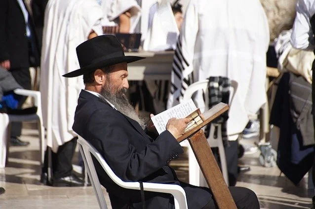 judeu sentado fazendo uma leitura lendo