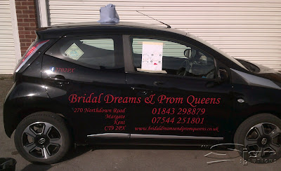 Vehicle livery in action: following the paper print out guide to apply the vinyl text to the car.