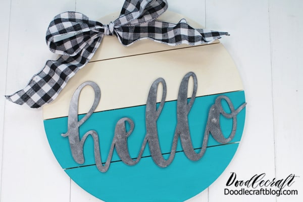 How to Make a Circle Wood Sign!   Make the perfect wood circle hello sign. These circle signs are all the rage and they are a perfect alternative to a wreath or door hanging.     Make a darling hello sign with a wooden circle pallet, some paint, ribbon and a galvanized hello!
