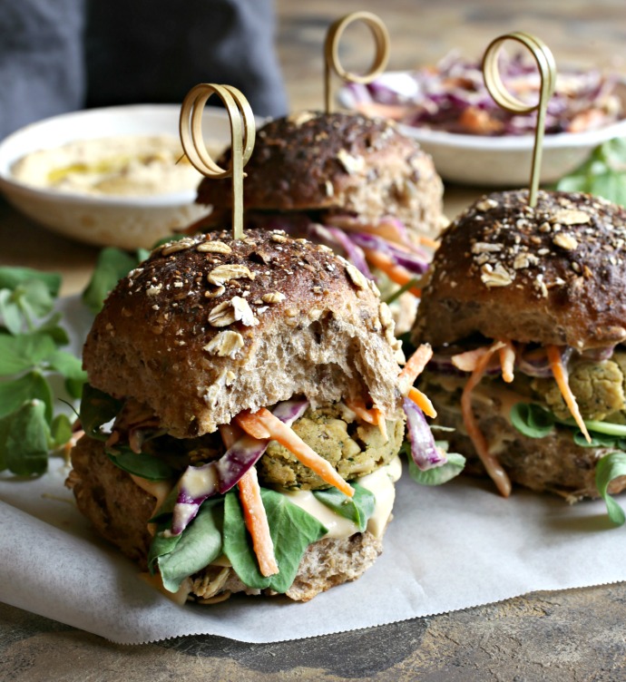 Recipe for baked chickpea and pine nut falafel patties topped with coleslaw in hummus dressing.