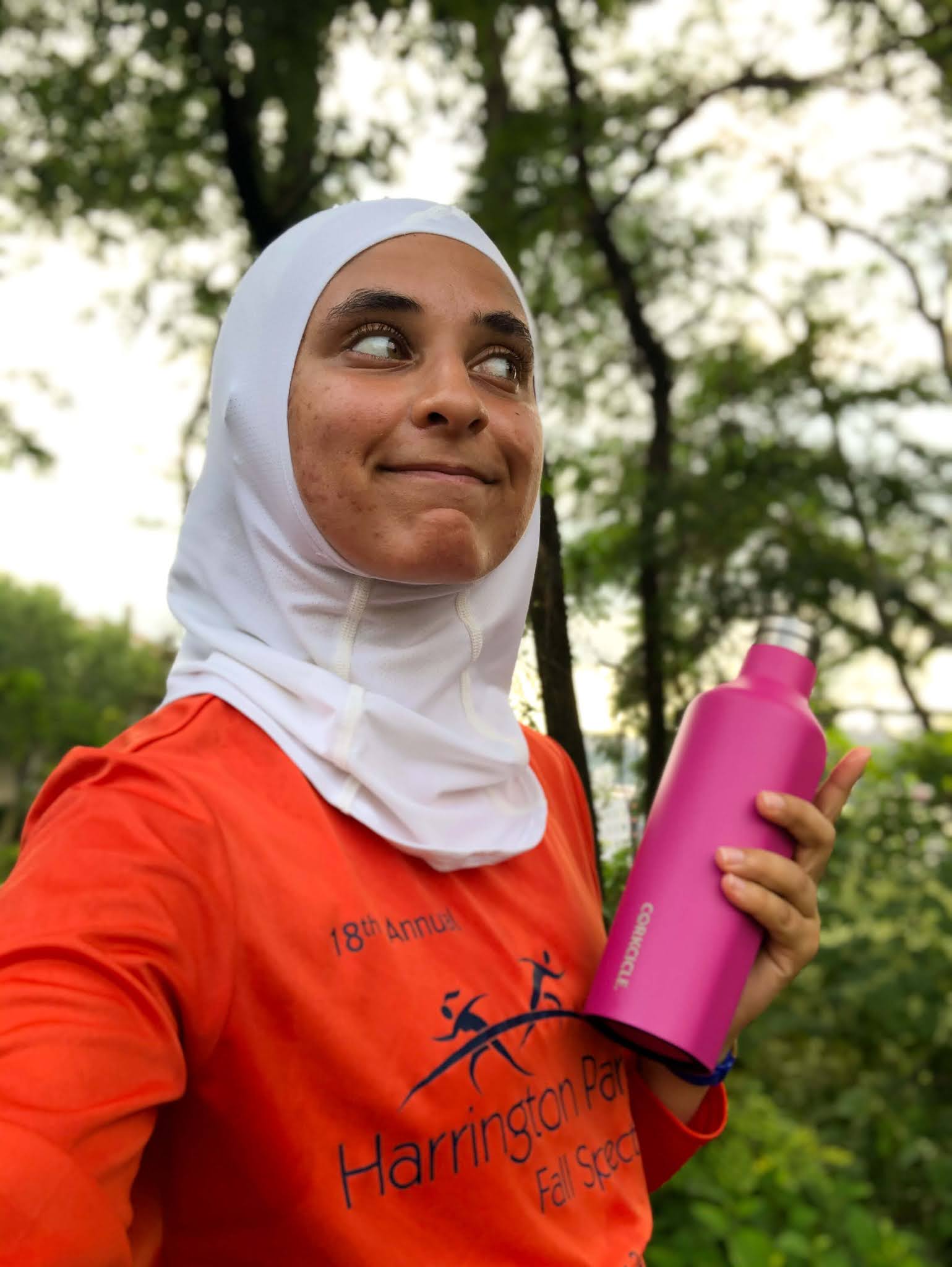 Sahara, bright orange long sleeve shirt, looking to side; side profile in image