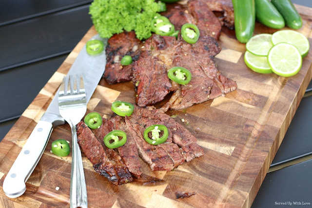 Tequila Lime marinated steak with lime and jalapenos on cutting board sliced