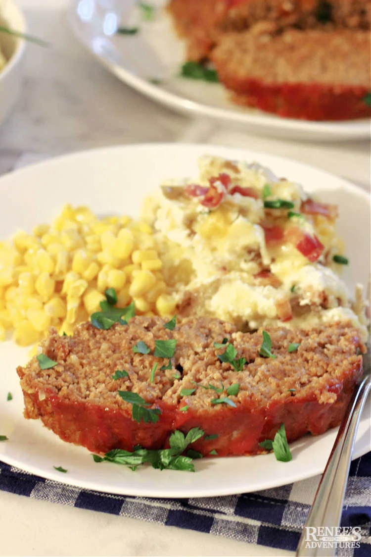 Plated Lipton Onion Soup Meatloaf with side dishes of corn and potatoes