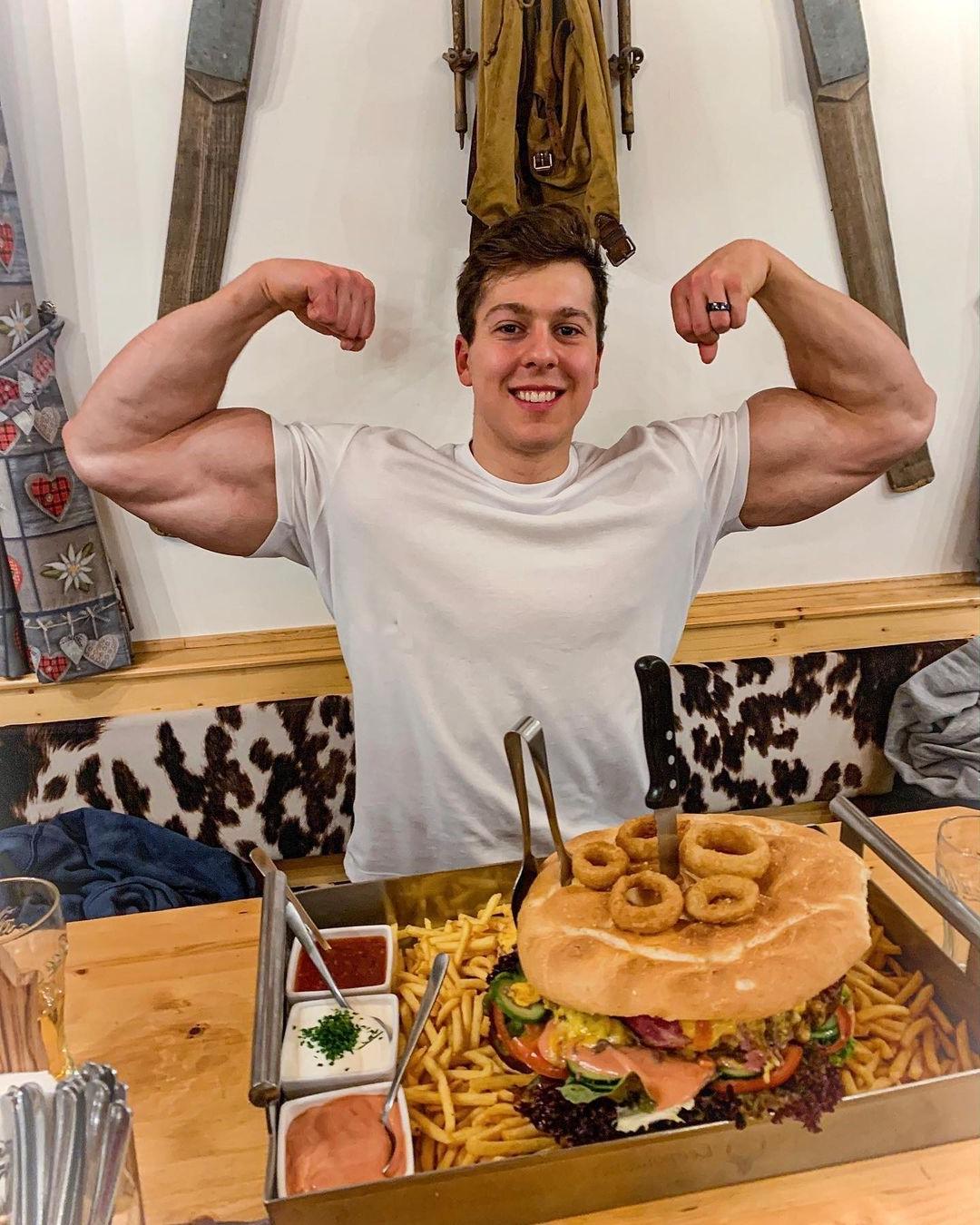 sexy-strong-bodybuilder-paul-unterleitner-smiling-huge-biceps-eating-fast-food-french-fries-restaurant