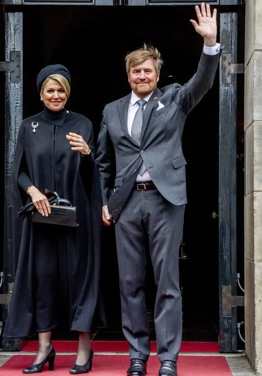 Queen Maxima wore a black wool fur collar cape coat. Black leather handbag. Pearl drop earrings and diamond brooch. Gripoix earrings