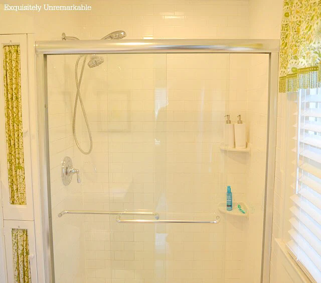 White tiled shower with glass doors