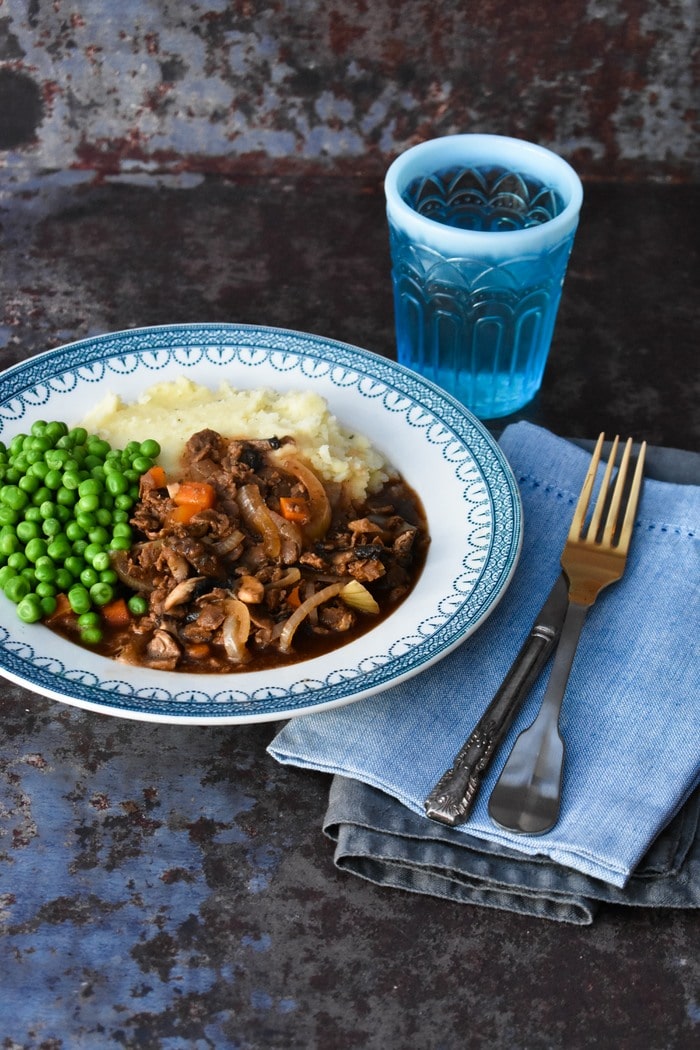 Slow Cooker Vegan Savoury Mince Served with Mash and Peas on a white plate