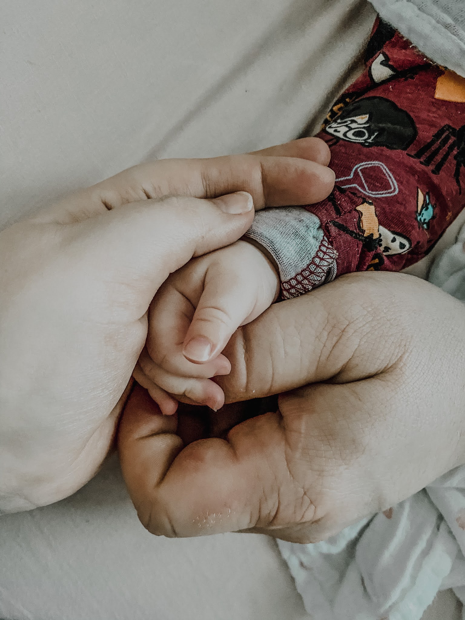 dłonie rodziców trzymające dłoń dziecka
