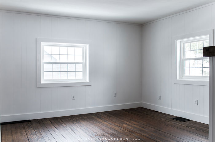 White paneled living room with windows