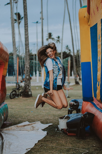 self care A girl mid-way jumping between two inflated jumping castles.