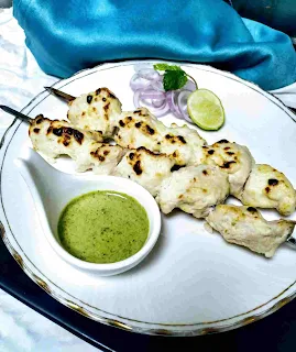 Serving chicken malai tikka with green chutney and onion lemon wedges