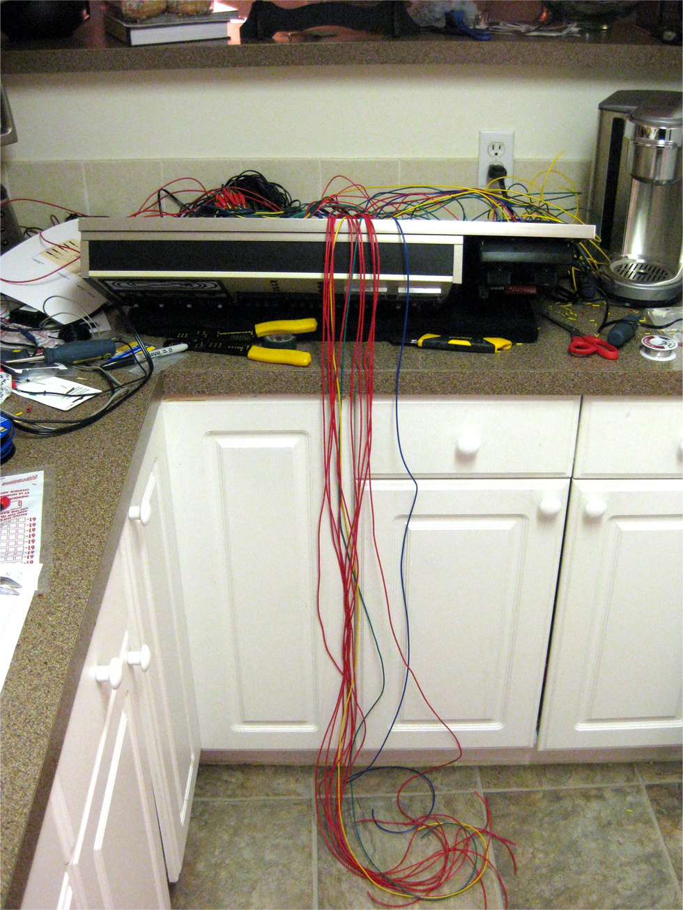 Wiring components together inside a model railroad control panel with long power leads hanging out