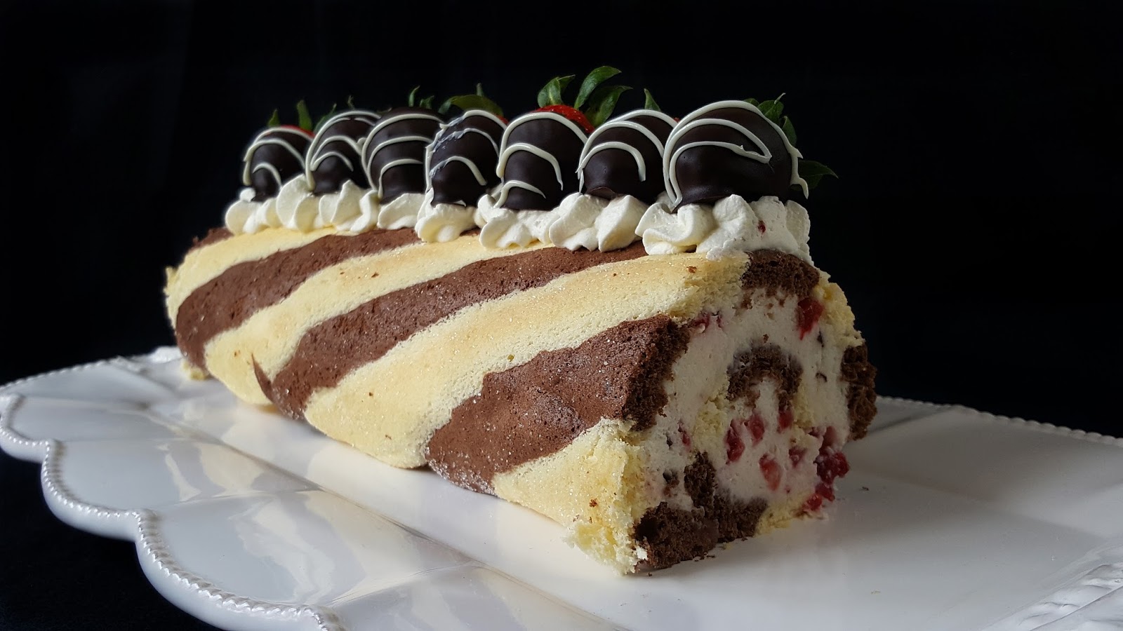 Zebra-Biskuitrolle mit Stracciatella-Erdbeerfüllung Zebra-Biskuitrolle mit Stracciatella-Erdbeerfüllung