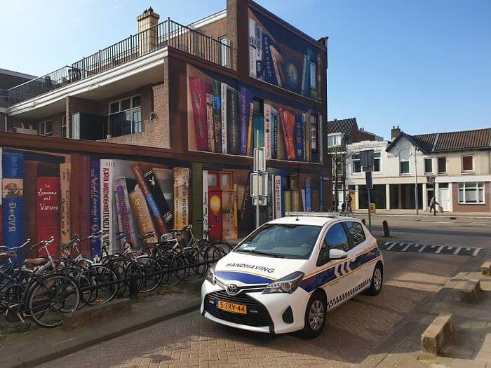 Dutch Artists Paint An Enormous Bookcase On An Apartment Building That Features Residents’ Favorite Books