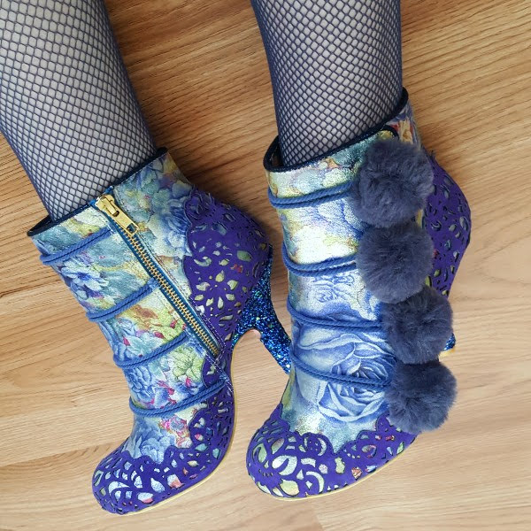 close up wearing ankle boots showing zip closure and pompom detail