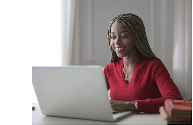 A lady happily using a laptop computer