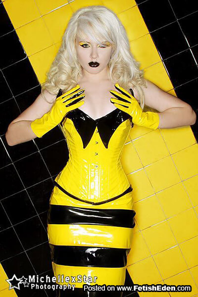 Hot blonde wearing yellow PVC skirt with black stripes and yellow PVC corset