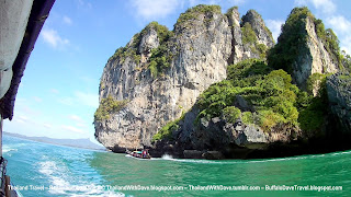 Longtail boat ride from Ao Nang to Railay - another longtail boat below the cliffs