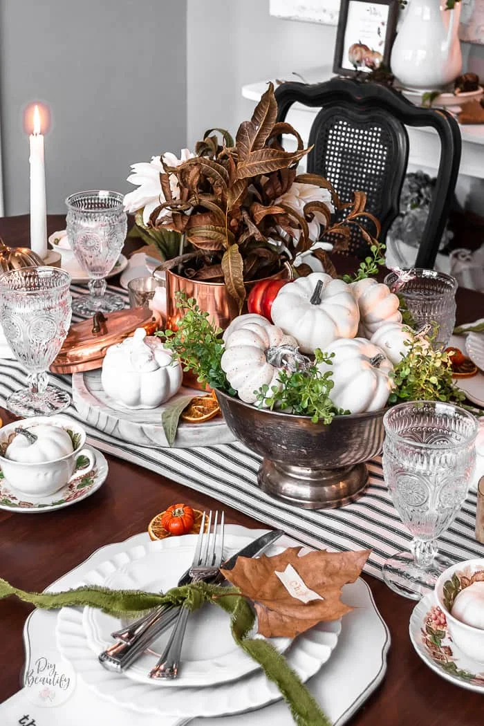 candles, goblets, striped runner, vintage teacups with white pumpkins for Thanksgiving table setting