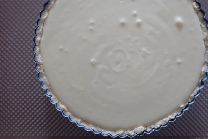 cheesecake filling in tart pan ready to bake