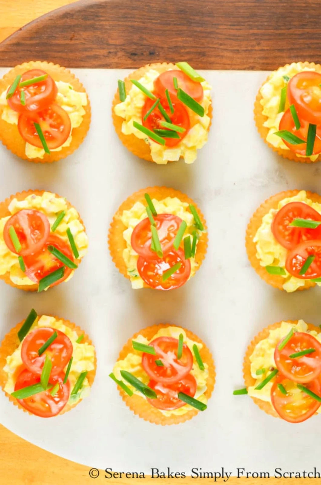 The best Egg Salad recipe on crackers with a slice or tomato and chive is perfect for an easy appetizer or light lunch. It also makes a delicious Egg Salad Sandwich from Serena Bakes Simply From Scratch.