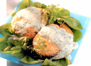 Salmon steaks served on a bed of lettuce and drizzled with a cheesy herb sauce