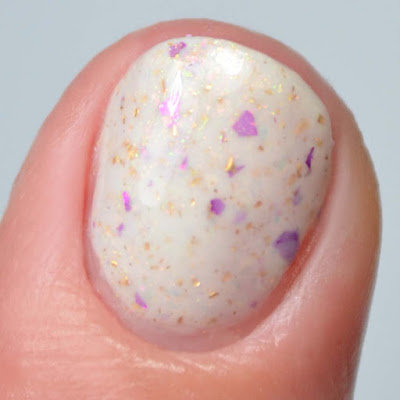 cream nail polish with flakies close up swatch