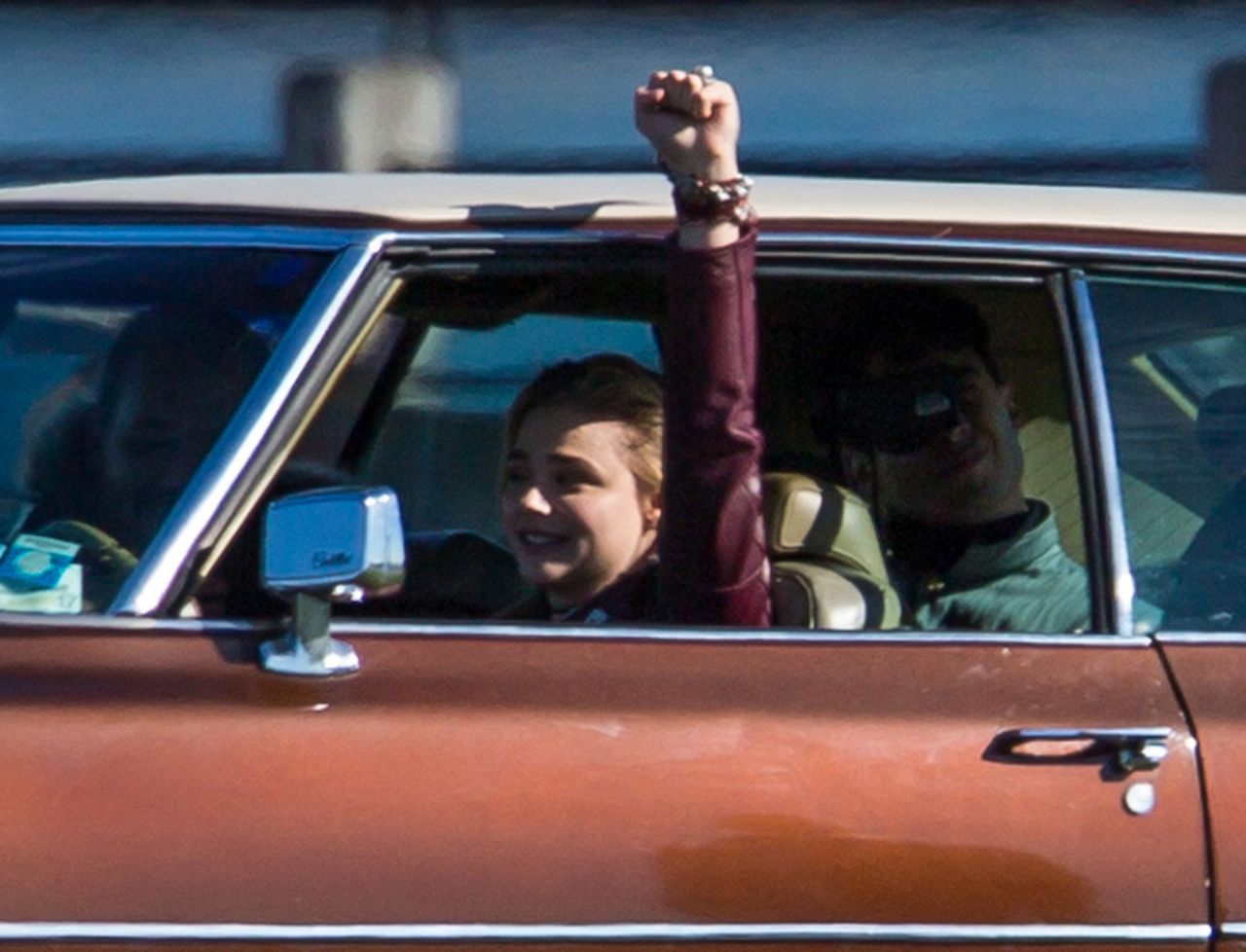 Chloezinha encarando um carro antigo