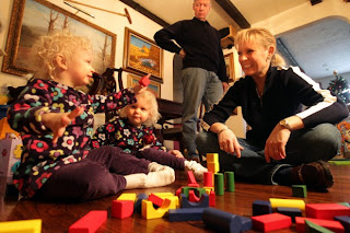 The Christian family, left to right, twins Reagan, and Darby, 2, and Fred and Linda play with building blocks in their Belleville home Monday Dec. 26, 2011. The girls were conceived through mini in vitro fertilization, a procedure advocated by St. Louis doctor Sherman Silber which, he says, is safer, cheaper and easier on women while maintaining comparable pregnancy rates.
