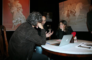 Stoisko galerii Omphalos, ludzie przy stoliku z laptopem