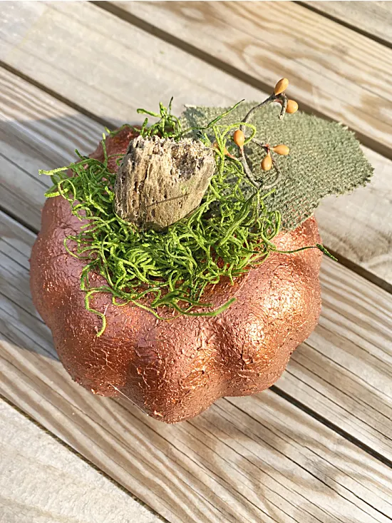 metallic pumpkin with moss and stem