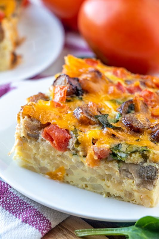 This breakfast casserole is great for Sunday morning breakfast, brunch or serve for the holidays! Tons of flavor from cheese, sausage, mushrooms, spinach, tomatoes, hash browns and onion. Simple to make and enough to feed the whole family!