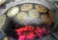 Cooking tandoori roti in a charcoal Ovalclay tandoor