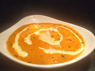 Garnished paneer butter masala in a bowl with cream and butter