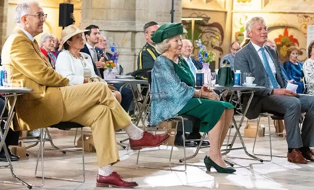 The Princess wore a green embroidered skirt suit, embroidered cape and green hat, gold brooch