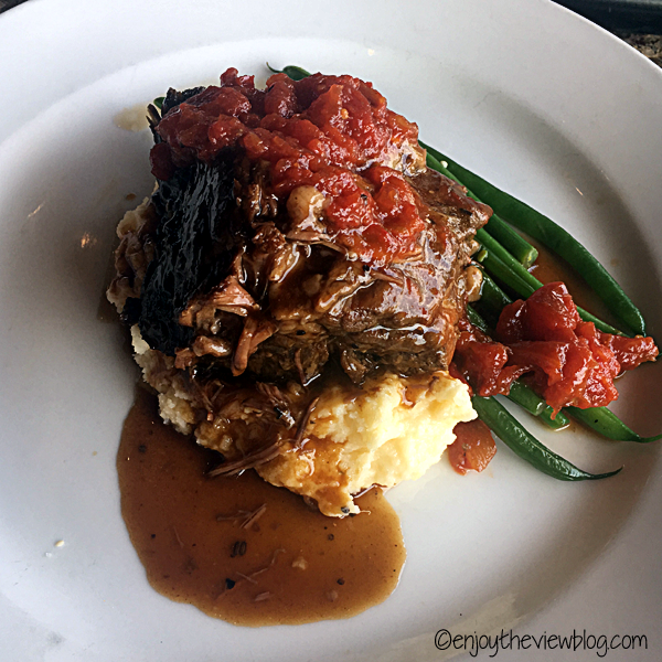 short ribs with tomato chutney, cheddar mashed potatoes, and green beans on a white plate