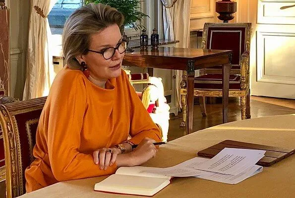 Queen Mathilde is honorary president of Unicef Belgium. Queen Mathilde wore a new orange silk blouse top from Natan, and orange earrings