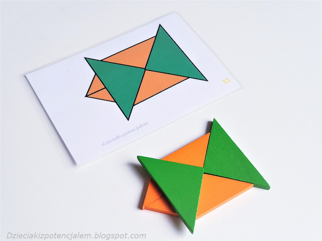 tangram wzory do wydruku, zdjęcie przedstawia kartę z wzorem przestrzennego tangramu oraz ułożone klocki, dwa pomarańczowe równoległoboki , po prawej stronie przylega do nich duży zielony trójkąt a na nich leży drugi zielony trójkąt tworzący lustrzane odbicie pierwszego