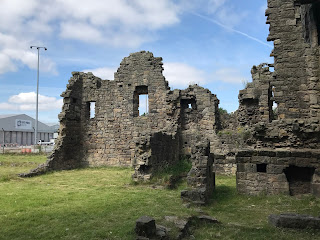 A photo of the ruined remains of the castle walls with dockyard buildings in the background.  Photo by Kevin Nosferatu for the Skulferatu Project