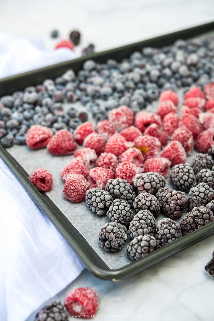 Freezing blackberries, raspberries, and blueberries will allow you to enjoy berries all year. Learn more at www.andersonandgrant.com. Frozen blackberries, raspberries, and blueberries on baking sheet