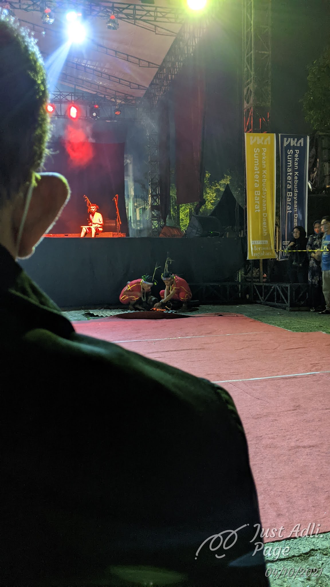Dua dari tiga pemusik sedang membakar sesuatu, sembari dua pemain lainnya melakukan suatu kegiatan di tengah-tengah pertunjukan.